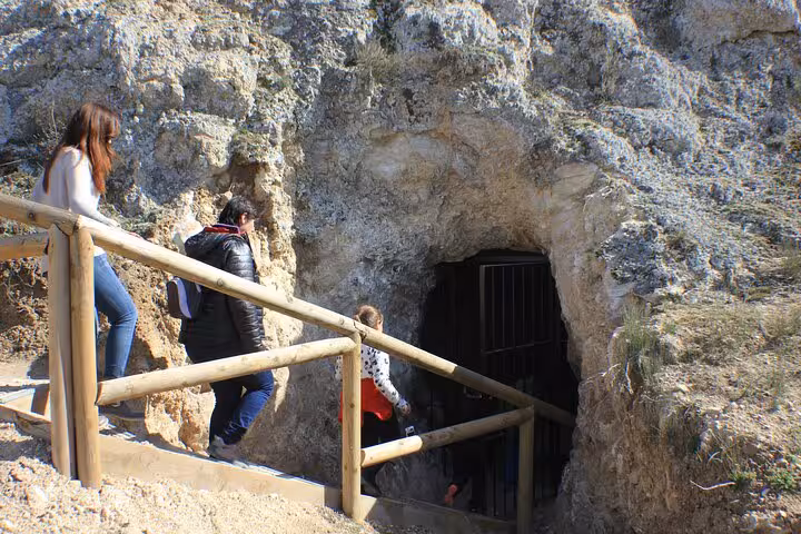 Visitors entering the Roman Lapis Specularis mine entrance on a guided tour near Osa de la Vega, Cuenca