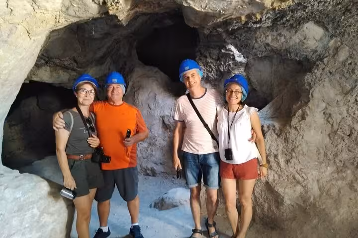 Tour group in blue helmets inside the Roman Lapis Specularis Mines, exploring ancient gypsum tunnels in Cuenca