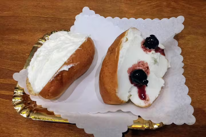 Traditional Roman maritozzo pastries filled with whipped cream and cherry jam on Monti district street food tour