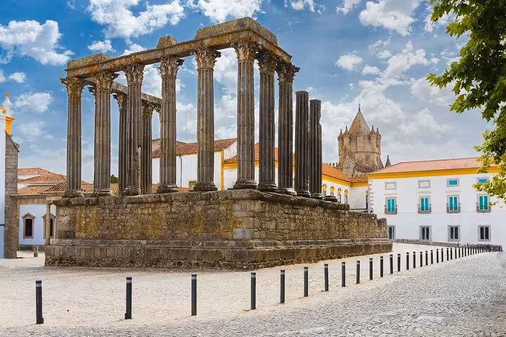 Roman Temple of Évora under a vibrant sky, highlighting ancient columns against the historic city backdrop.