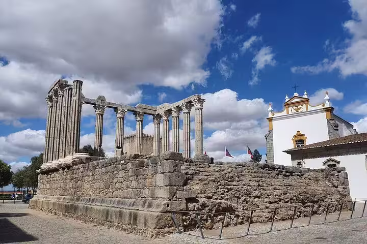 Ancient Roman temple ruins in Évora under a vibrant sky, featured on the Evora & Monsaraz Private Full-Day Tour from Lisbon.