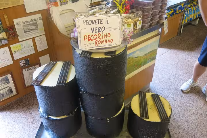 Discover authentic Pecorino Romano cheese in a local shop, a highlight of the Roman Walkin Foodies Tour.