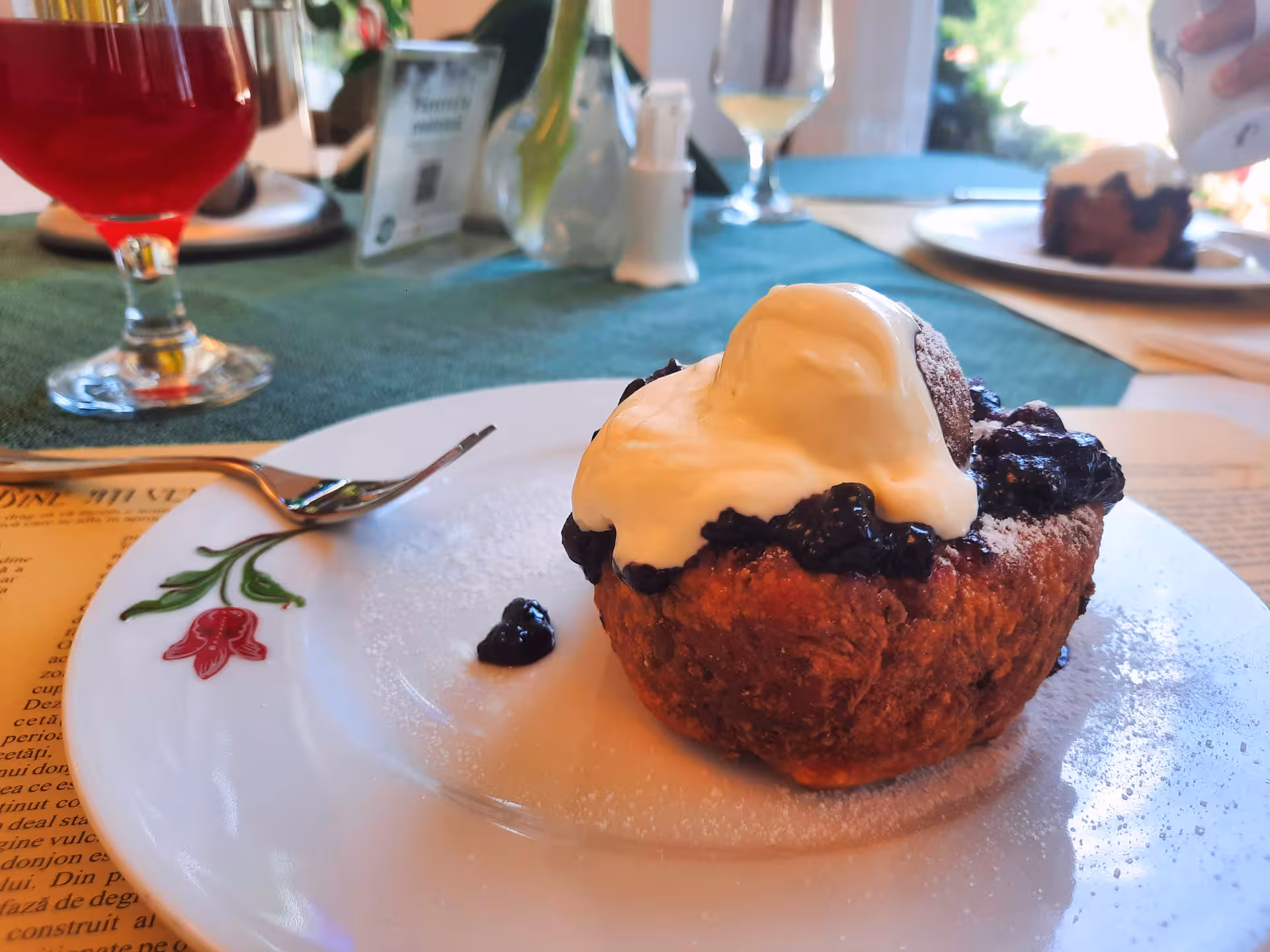 Traditional Romanian dessert with blueberry topping and cream served during Turda Salt Mine day trip from Cluj