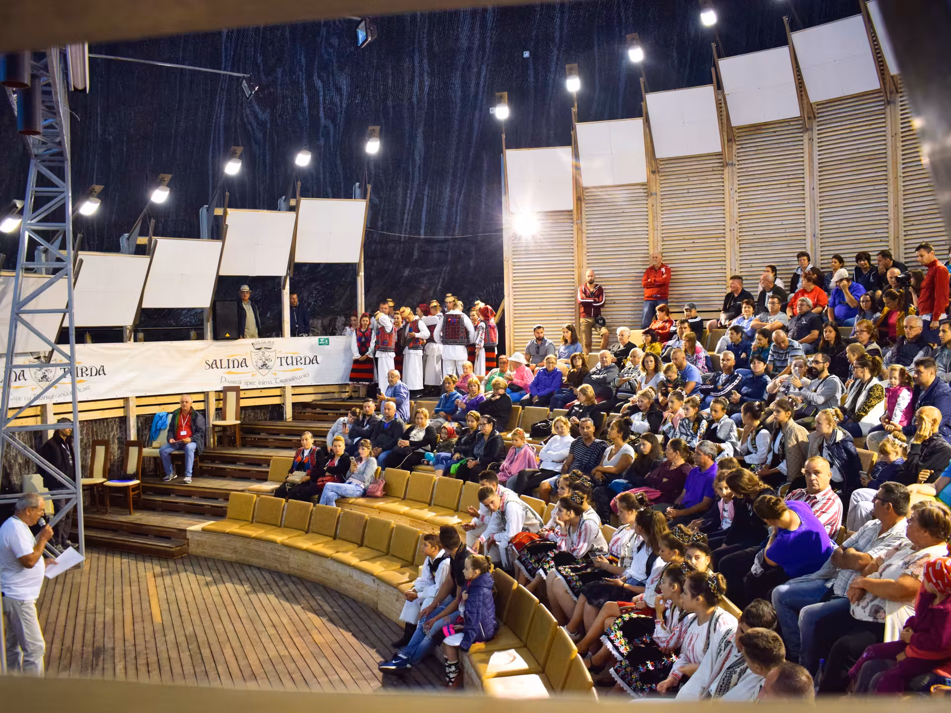 Traditional Romanian folk dance performance inside Salina Turda underground amphitheater during a cultural full-day tour