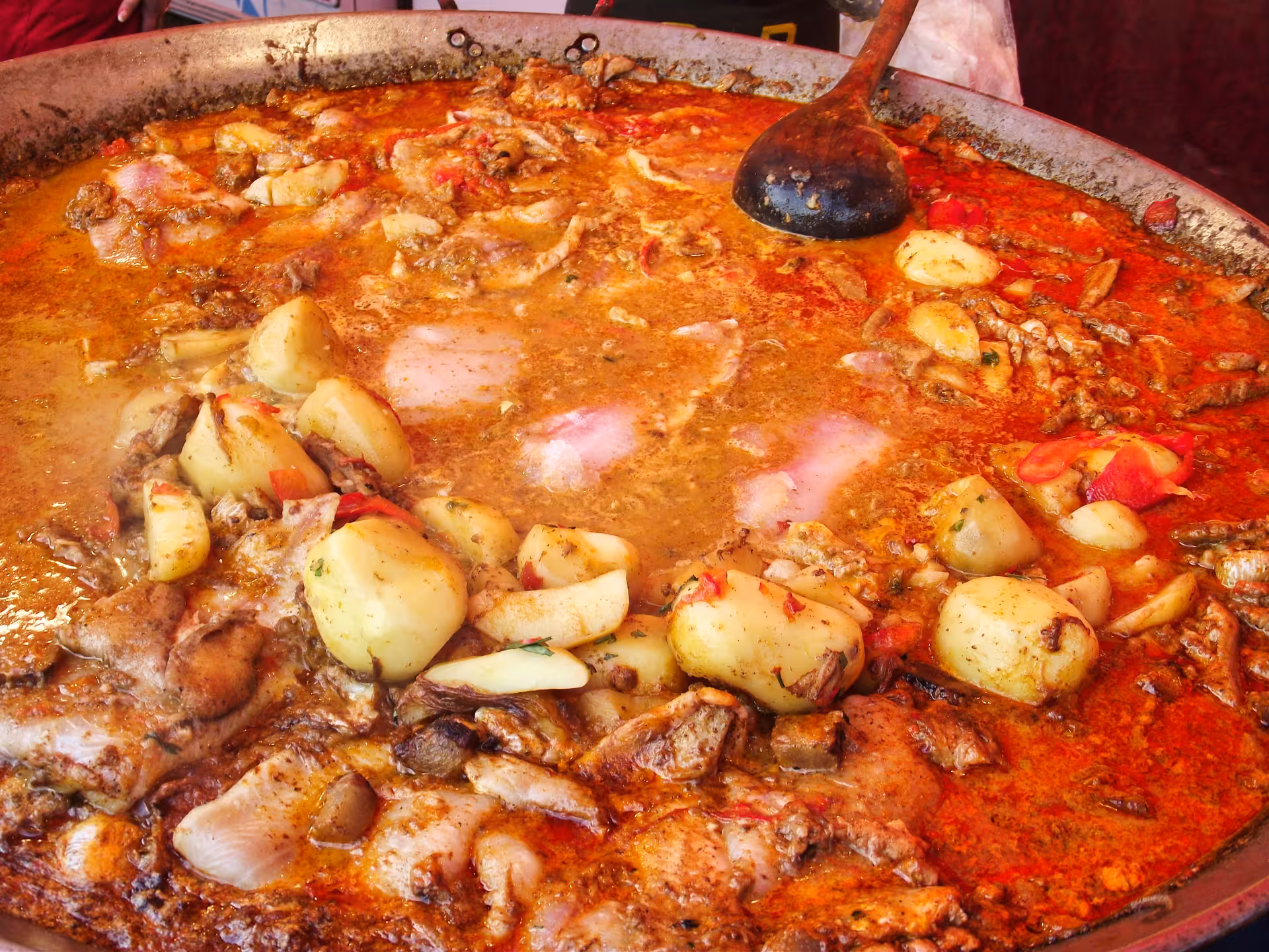 Giant pan of hearty Romanian meat and potato stew simmering at Negreni Flea Market guided tour street food experience
