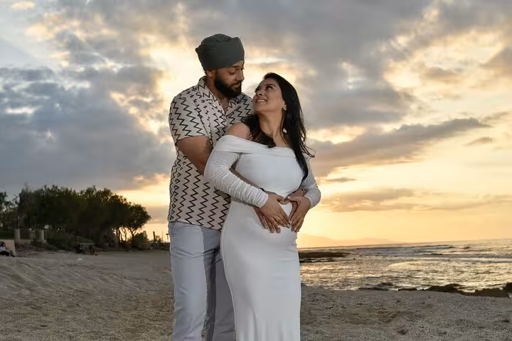 Romantic couple embrace on Ammoudara beach at sunset, highlighting intimate moments during a private photoshoot experience.