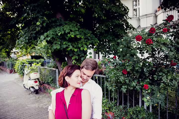Romantic couple photo in a Berlin street by red roses, private vacation photographer tour and portrait session