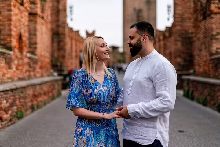 Smiling couple holding hands on a historic Verona street, perfect for a professional photoshoot capturing love and culture.
