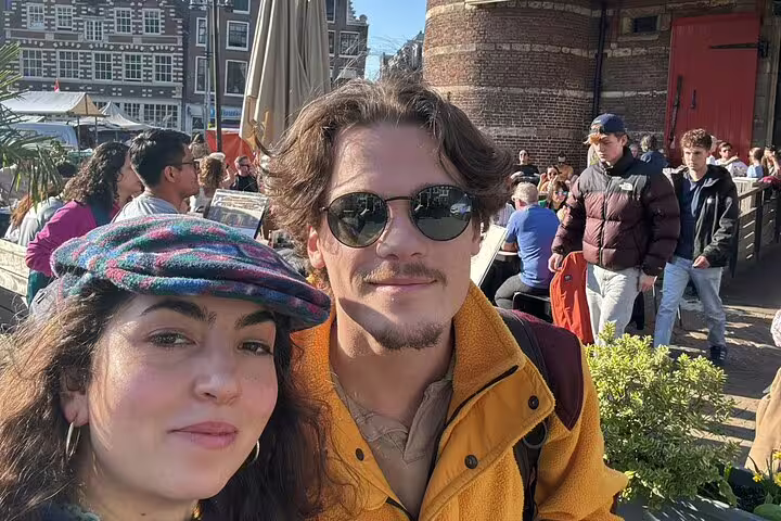 Couple posing for selfie at outdoor café in Amsterdam city center on sunny day