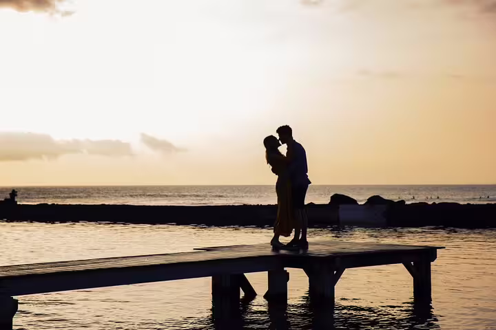 Romantic couple silhouette kissing at sunset on a pier in Tenerife during a private professional photoshoot