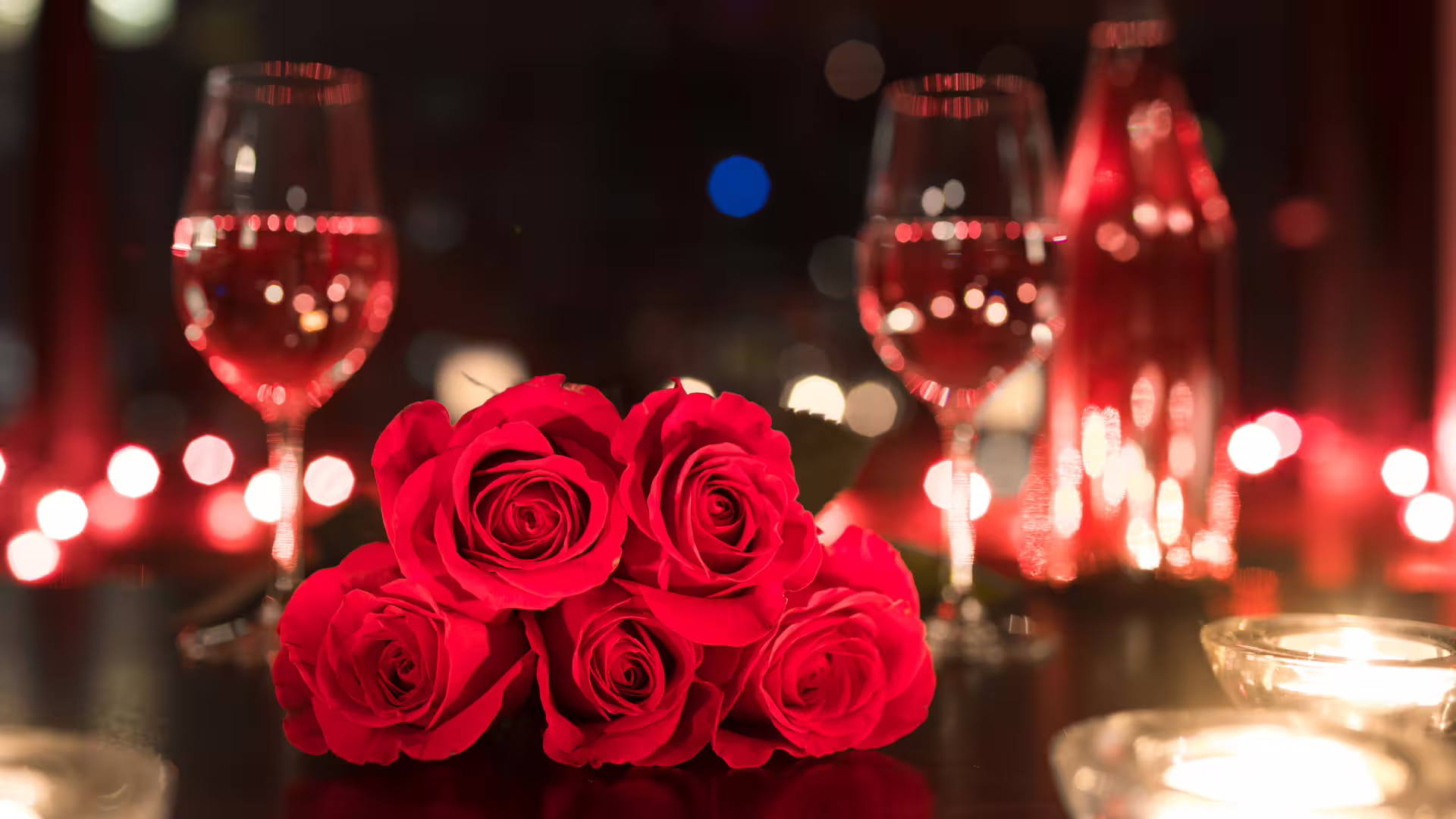 Red roses, candlelight and wine glasses set an intimate dinner scene for a romantic Solofra couple’s getaway experience