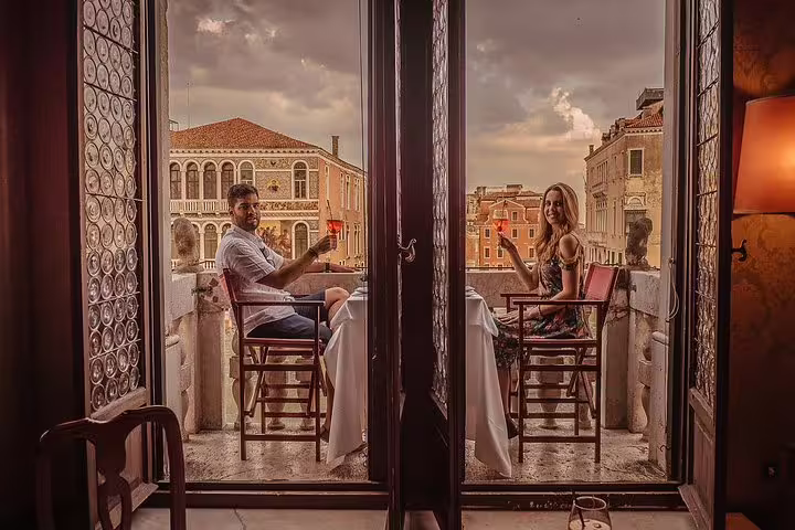 Couple enjoying a romantic dinner on a Venetian palace balcony, overlooking the picturesque canals and historic architecture.