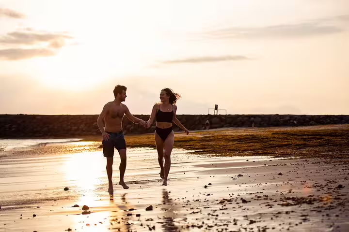 Romantic Tenerife sunset beach photoshoot with professional photographer capturing couple walking by the sea