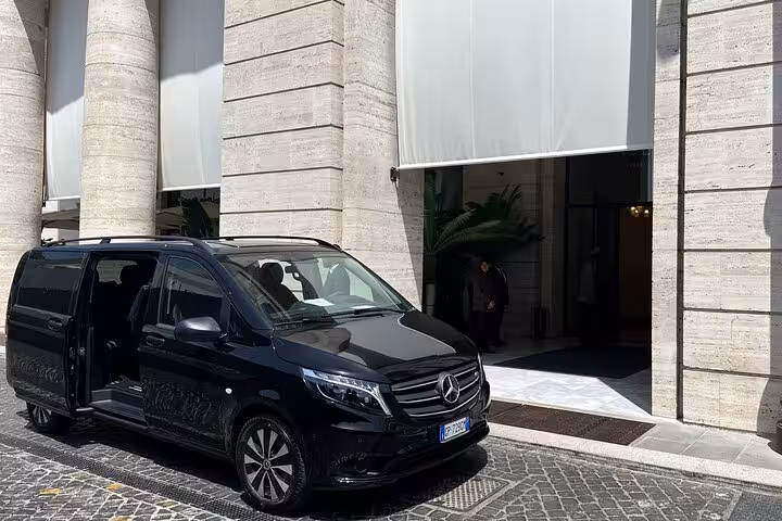 Sleek black Mercedes van parked outside a grand building, ideal for Rome to Amalfi Coast private transfers.
