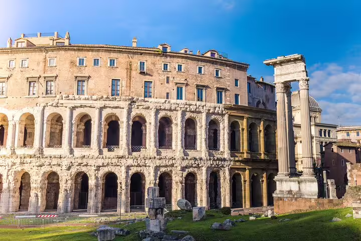 Ancient Roman theater ruins with towering columns under a clear blue sky, featured in a private walking tour of Rome's secrets.