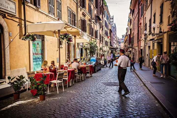 Charming Italian street scene with outdoor dining, perfect for an aperitivo tour near the Vatican with authentic local ambiance.