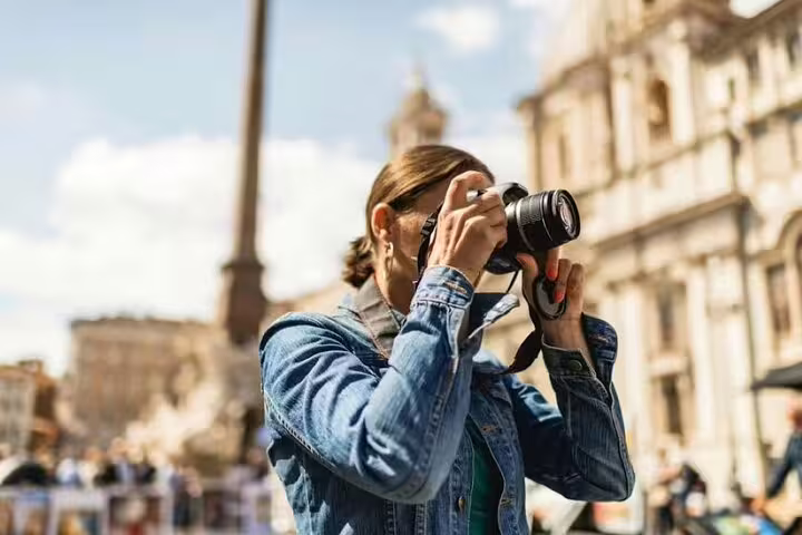Traveler photographing historic Baroque architecture in Piazza Navona on a Love Affairs and Papal Power small group tour Rome