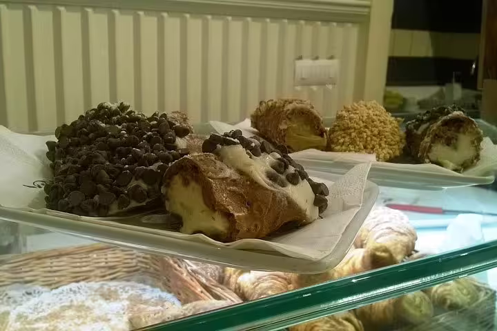 Fresh Italian cannoli with chocolate chips displayed at a Rome bakery on a Navona dessert guided tour stop