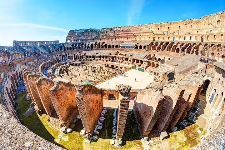 Interior of the Colosseum in Rome on a private guided tour, showcasing ancient arena ruins under a bright blue sky