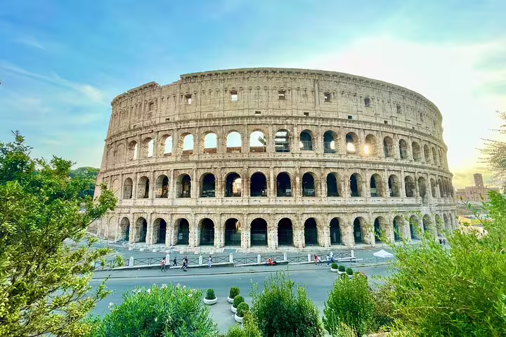 Panoramic view of the Colosseum in Rome at sunset, included in chauffeured transfers and skip-the-line private tours