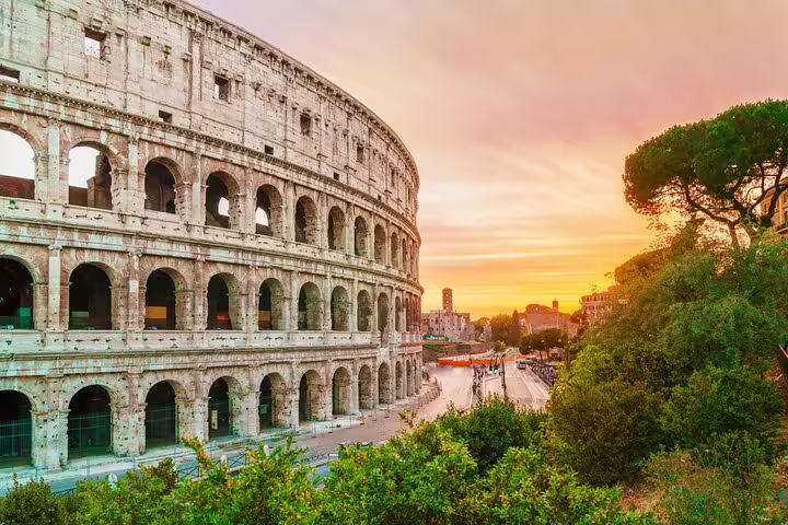 Sunset view of the Rome Colosseum exterior with ancient arches and VIP skip-the-line tour access on a private city walk