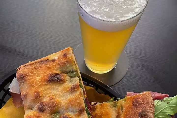 A refreshing pint of craft beer paired with a gourmet sandwich, highlighting the Vatican's Craft Beer Private Tour with a local foodie.