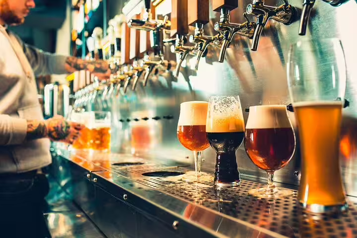 A variety of craft beers being poured from taps, highlighting the Vatican's Craft Beer Private Tour with a local foodie guide.