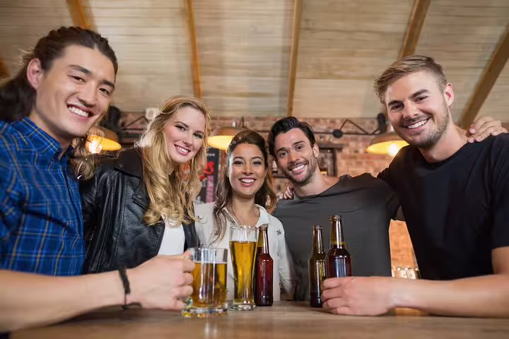 A group of friends enjoying craft beers during a Vatican private tour with a local foodie, showcasing vibrant social experiences.
