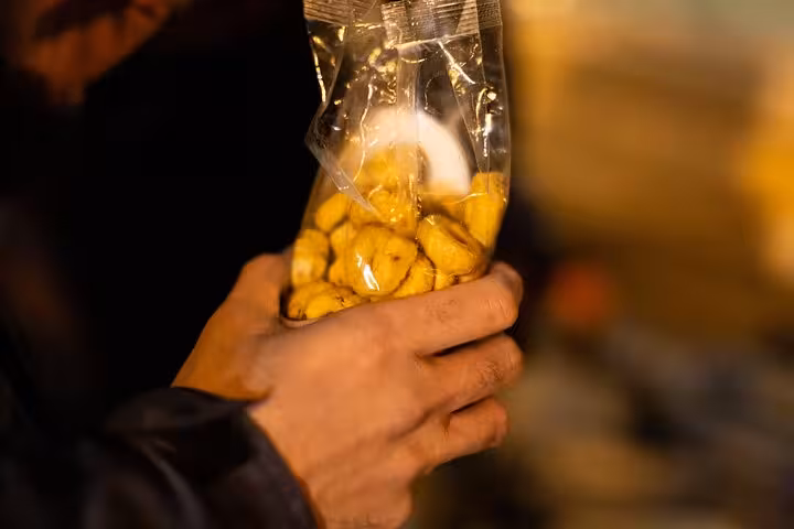 Close-up of hands holding a bag of snacks during a private Rome night craft beer walking tour.