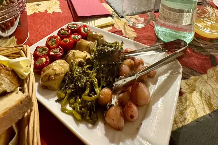 Plate of Italian antipasti with marinated vegetables and bread on a rustic table during Rome Fabullus tasting menu tour