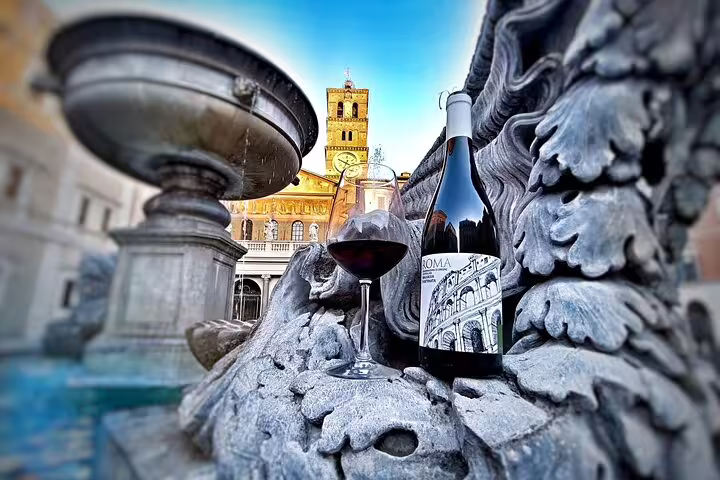 Glass and bottle of Roma red wine from the Fabullus menu set on a historic fountain in a scenic Rome piazza at dusk
