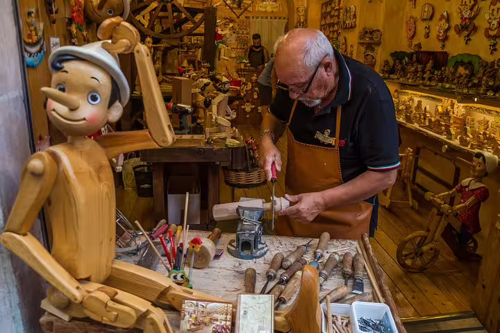 Artisan crafting wooden Pinocchio dolls in a traditional Roman workshop, featured on the Bella Roma family tour for kids.
