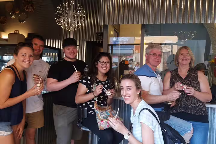 Happy tour group enjoying gelato together inside a Rome gelateria on a Pantheon dessert guided tour