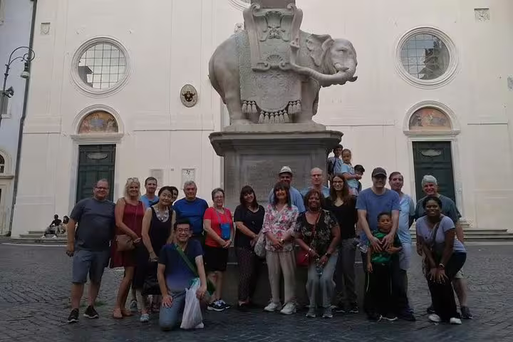 Tour group posing by elephant obelisk sculpture near Pantheon on Rome Ghetto street food tour