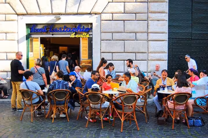 Tourists enjoy outdoor seating at a popular Roman cafe, highlighting local culture on the Rome golf cart tour.