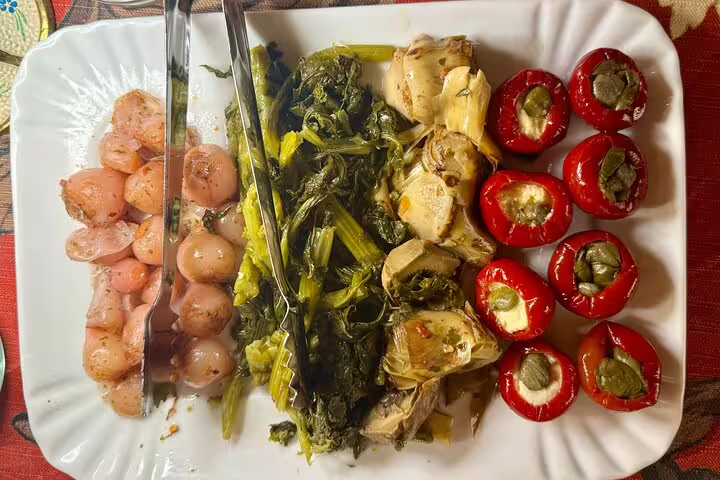 Gourmet antipasti plate in Rome with marinated onions, leafy greens, artichokes and stuffed peppers for Fabullus menu