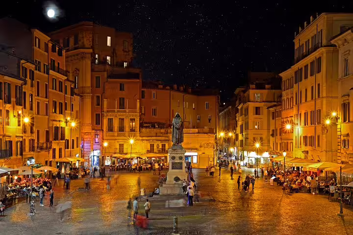 Campo de' Fiori square at night in Rome with statue and illuminated cobblestone piazza