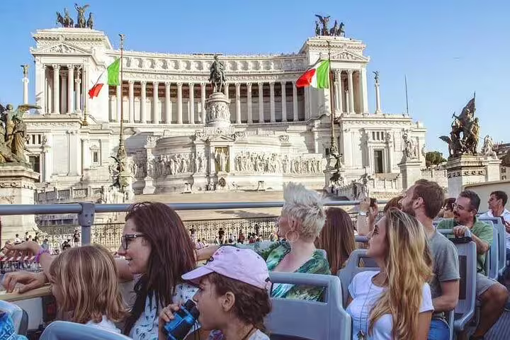 Families on a Rome hop on hop off open bus admiring the Vittoriano monument during a combined city sightseeing and Vatican tour