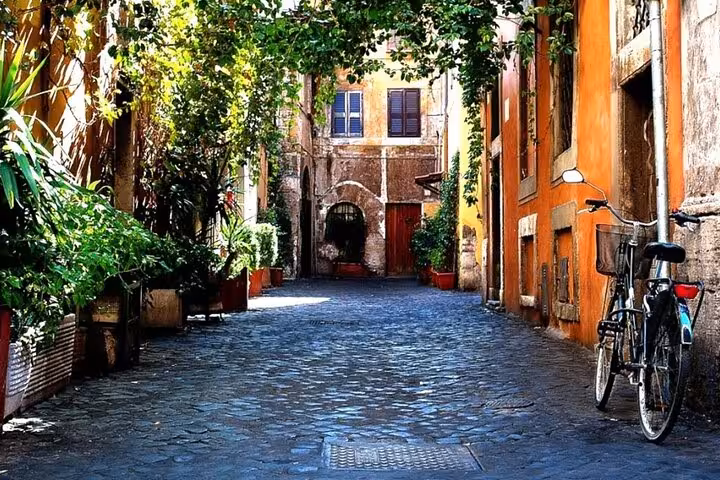 Charming cobblestone alley in Rome's Jewish Ghetto, featuring rustic architecture and lush greenery, perfect for a cultural tour.