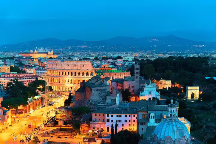 Twilight view of illuminated Colosseum and Roman Forum seen on a private chauffeured Best of Rome by Night tour
