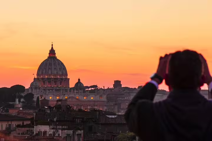 Traveler admiring St Peter’s Basilica at sunset from a panoramic terrace on a Best of Rome by Night private chauffeur tour