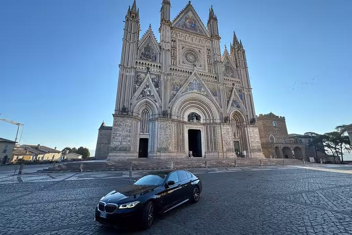 Luxury BMW private transfer car in front of Orvieto Cathedral for a premium Rome to Orvieto private driver service