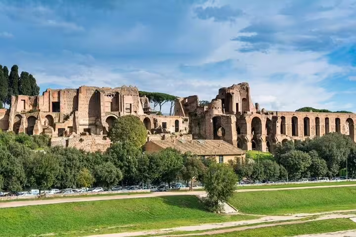 Panoramic view of ancient Palatine Hill ruins and green parkland included on the Rome Hop On Hop Off open bus tour route