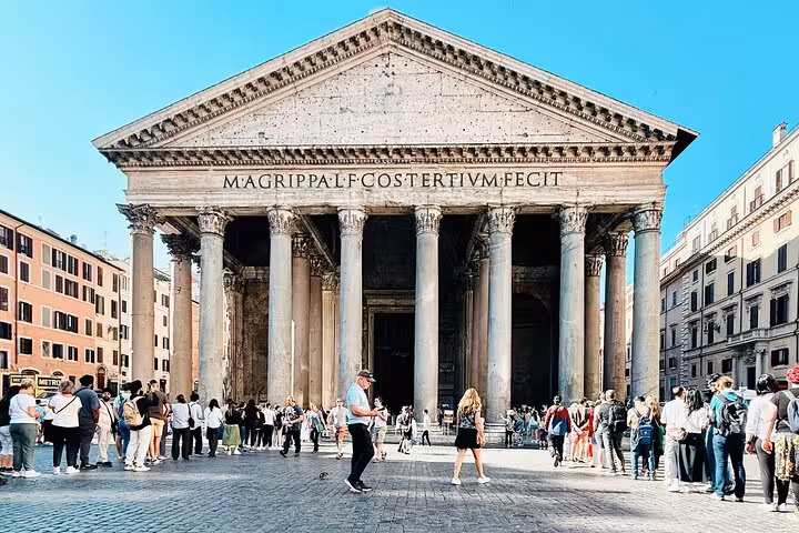 Tourists gather outside the grand facade of Rome's Pantheon under a clear blue sky, enjoying a fast track tour.
