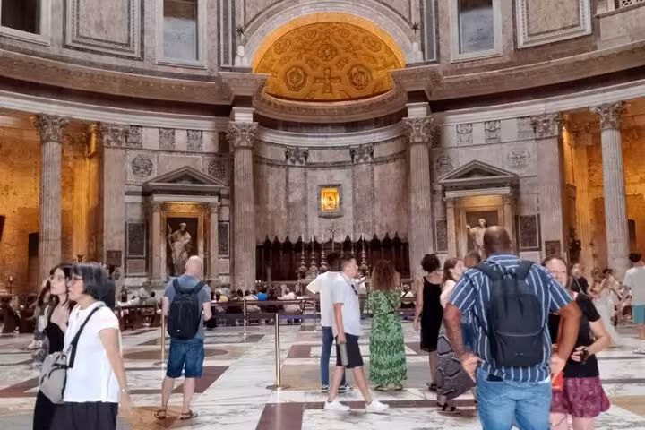 Visitors explore the historic interior of Rome's Pantheon, marveling at its ancient architecture and grandeur.