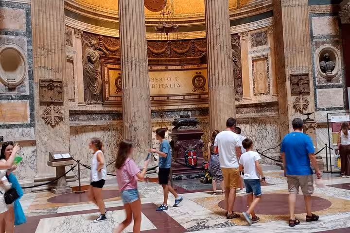 Visitors exploring the majestic interior of Rome's Pantheon, surrounded by its grand columns and historical artifacts.