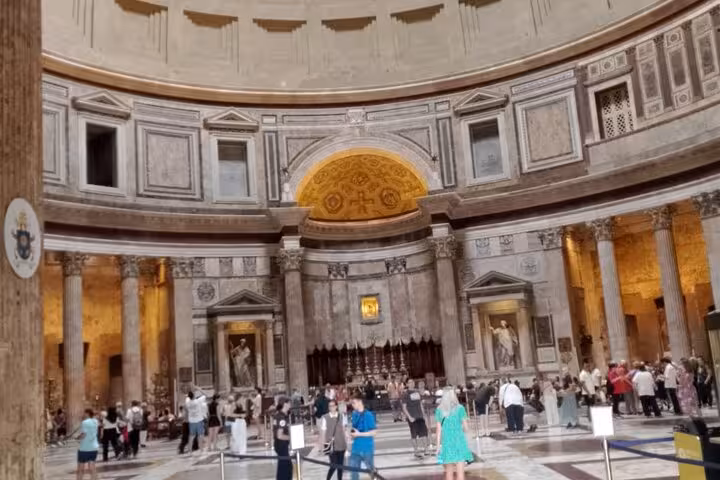 Visitors explore the grand interior of Rome's Pantheon, highlighting its ancient architecture and ornate details.