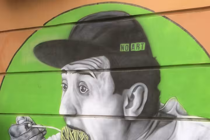 Colorful street art in Pigneto, Rome, depicting a man eating spaghetti, enhances the craft beer tour experience.