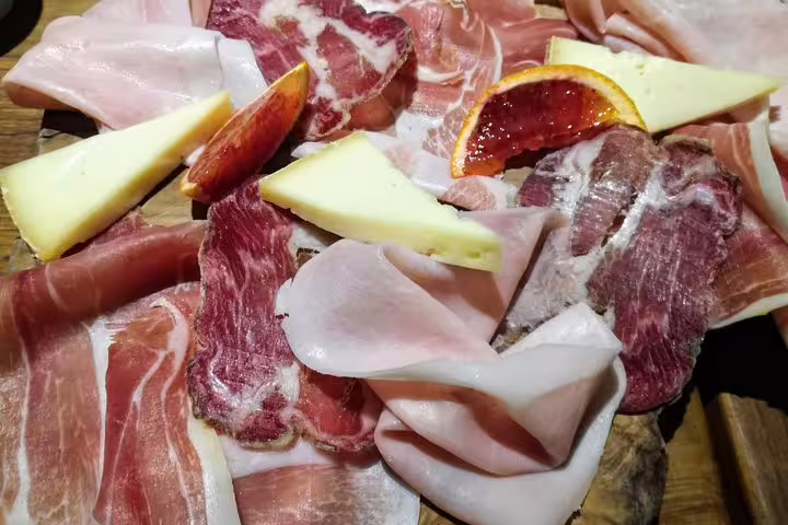 Italian charcuterie board with cured meats, aged cheese, and blood orange on Rome street food tour