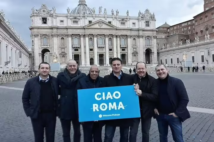 Group of tourists at St. Peter's Square, Rome, excitedly holding a sign for a memorable city tour.